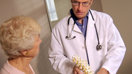 doctor showing a spine to a woman