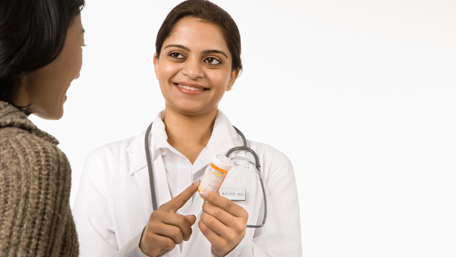 a pharmacist showing pills to patient