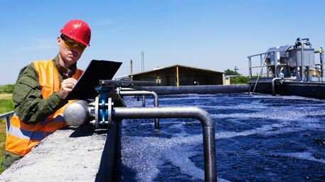 a worker recording data from a water treatment facility